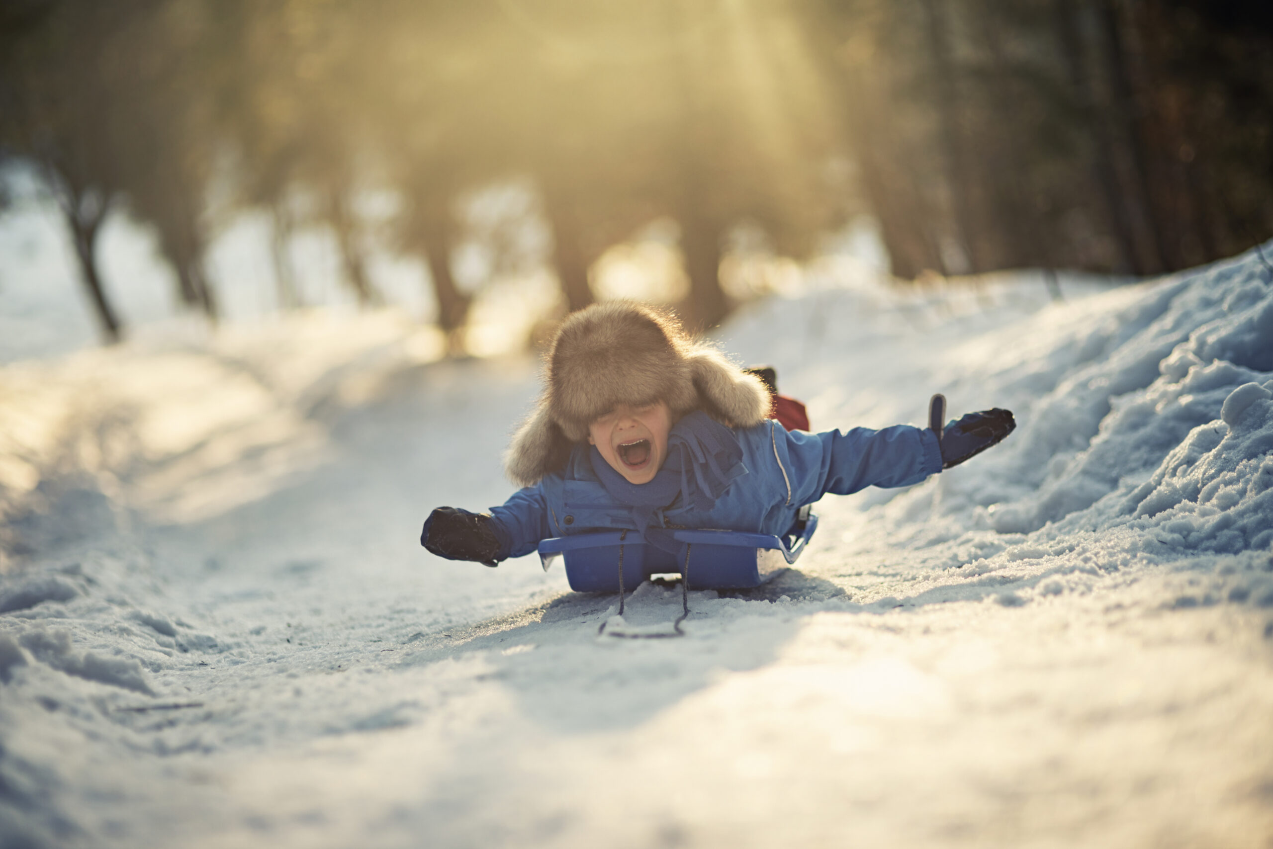 Child slidding down a hill in the winter