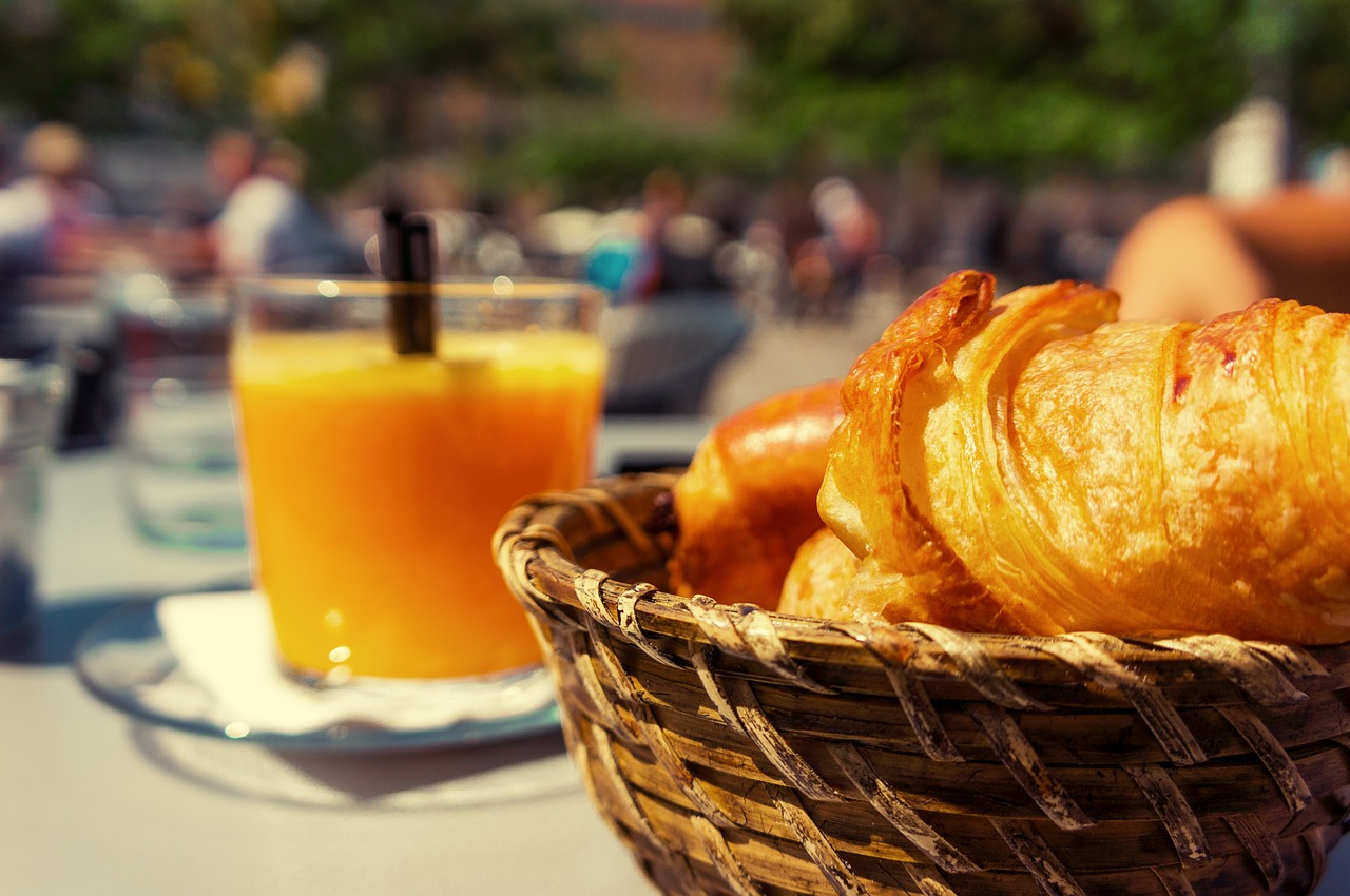 Breakfast, brunch, orange juice and croissants in a basket.